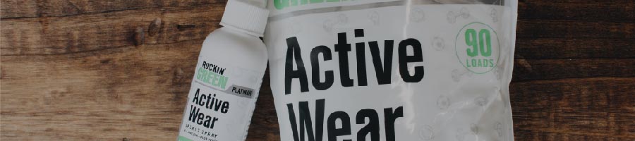 Active Wear laundry detergent bottle and 90-load bag on a wooden surface.