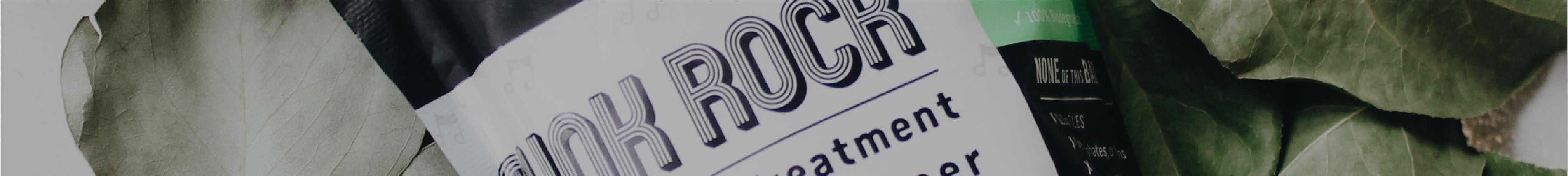Close-up of a product label reading “ROCK treatment” with green leaves in the background.