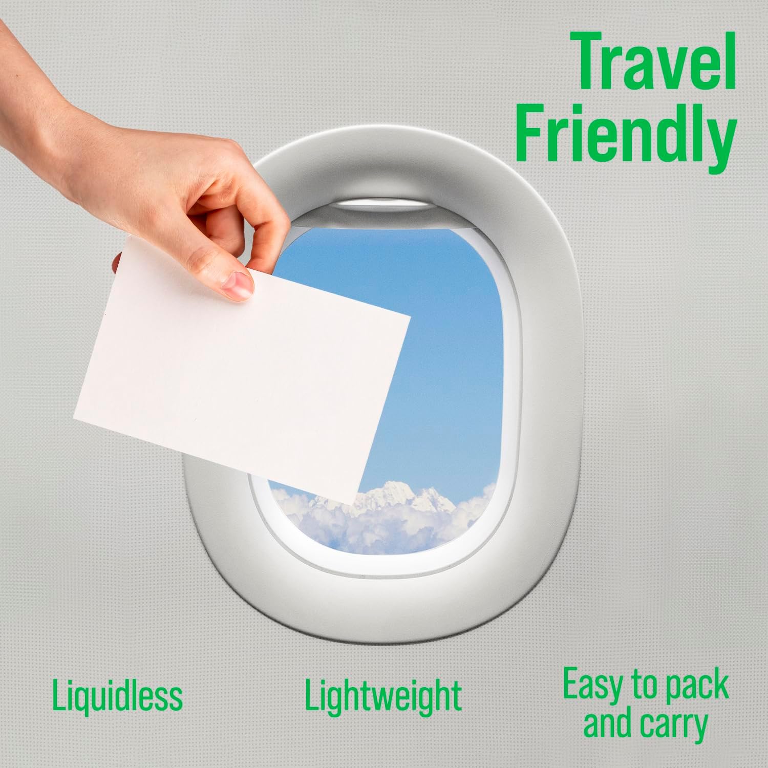 A hand holds a white card by an airplane window: Rockin Green AC/DSea Breeze Detergent Sheets.