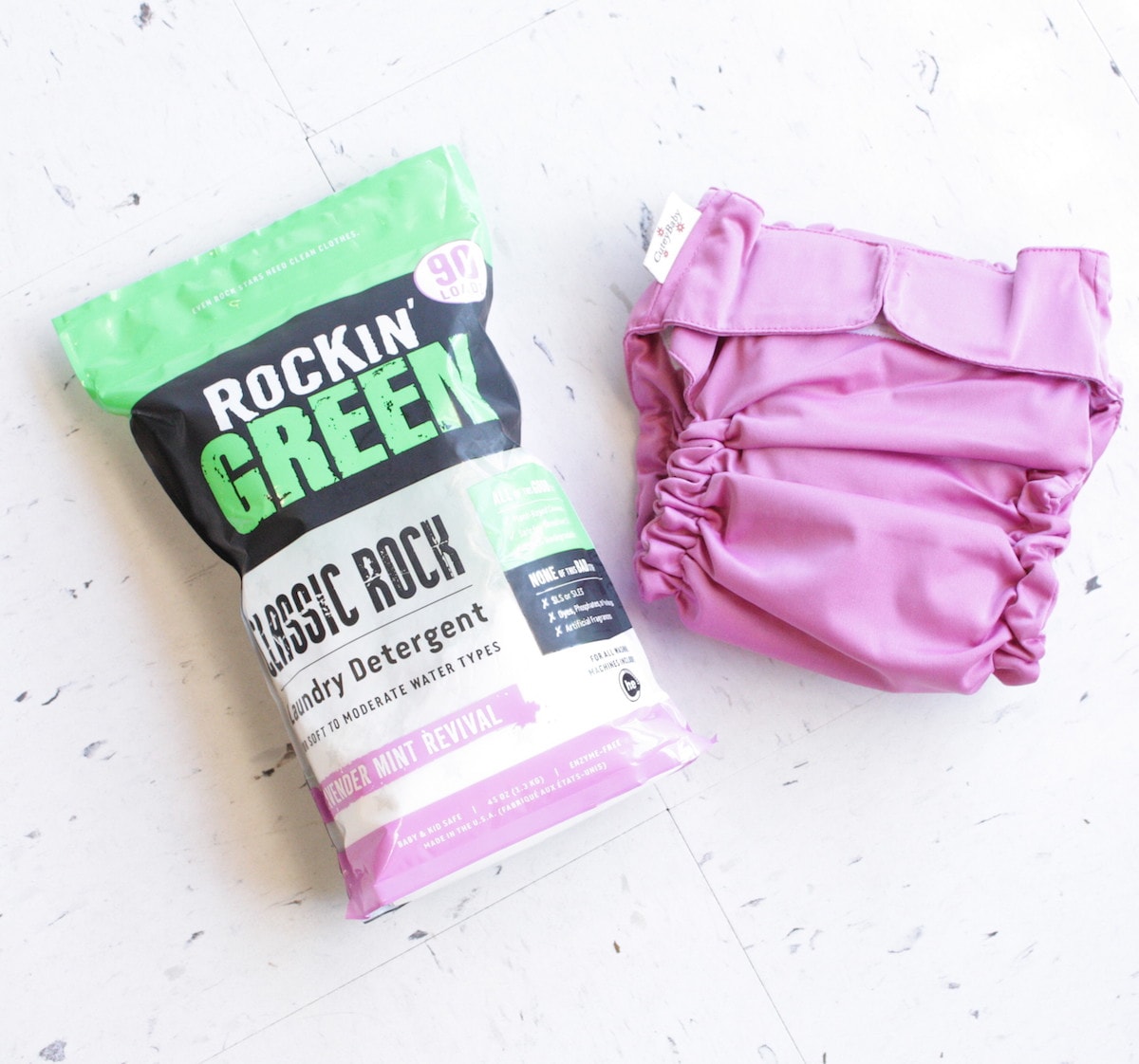 Rockin Green Lavender Mint detergent & pink cloth diaper on floor—perfect for sensitive skin.